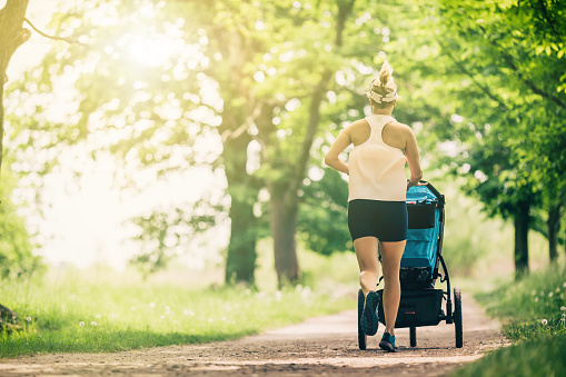 Running woman with baby stroller