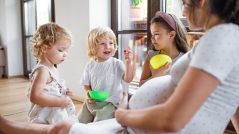 Pregnant woman with small children indoors at home