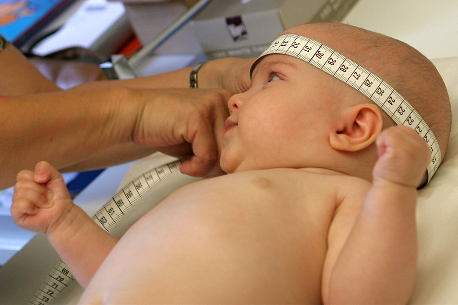Baby having head measured
