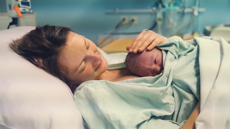 Lady cuddling baby after giving birth